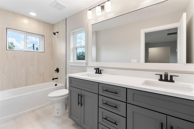 full bath featuring double vanity, bathing tub / shower combination, a sink, and toilet