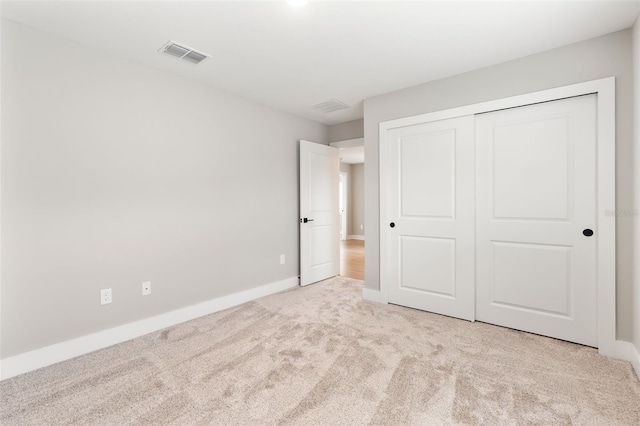 unfurnished bedroom featuring carpet floors, baseboards, visible vents, and a closet