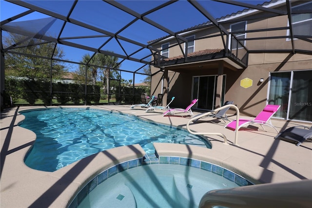 view of pool featuring a pool with connected hot tub, glass enclosure, and a patio