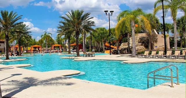 pool with a water slide, a patio, and a gazebo