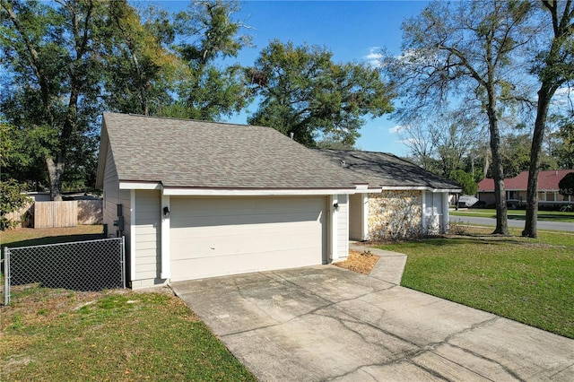 view of front of house with a detached garage, fence, a front lawn, and roof with shingles