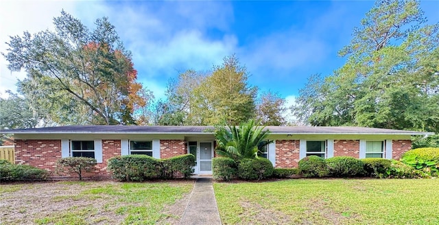 single story home featuring a front yard and brick siding