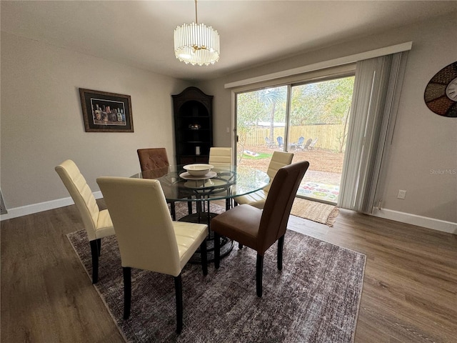 dining space with a chandelier, dark wood-type flooring, and baseboards