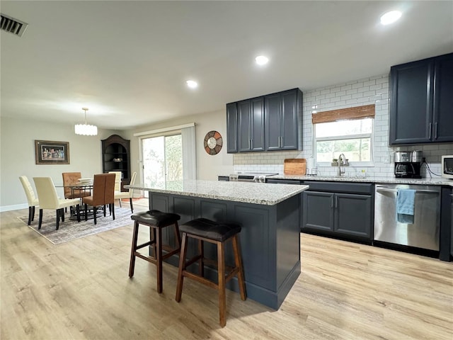 kitchen featuring visible vents, pendant lighting, dishwasher, and a center island