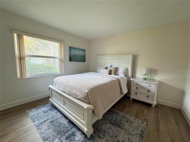 bedroom featuring dark wood-style flooring and baseboards