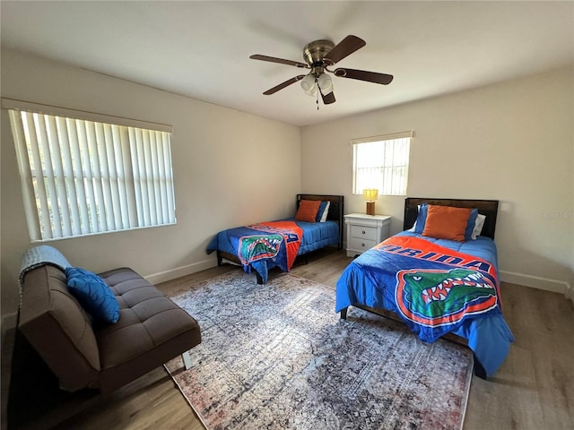 bedroom with a ceiling fan, light wood-type flooring, and baseboards