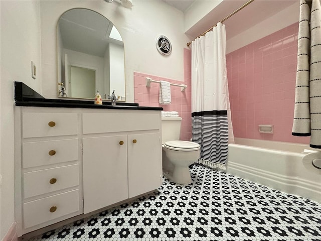 full bath featuring shower / tub combo, visible vents, toilet, vanity, and tile walls