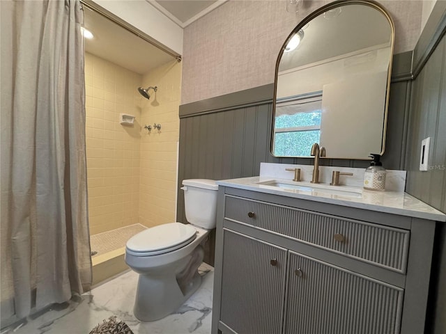 bathroom with toilet, vanity, marble finish floor, wainscoting, and a stall shower