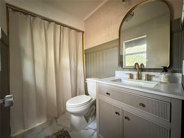 bathroom with marble finish floor, vanity, and toilet