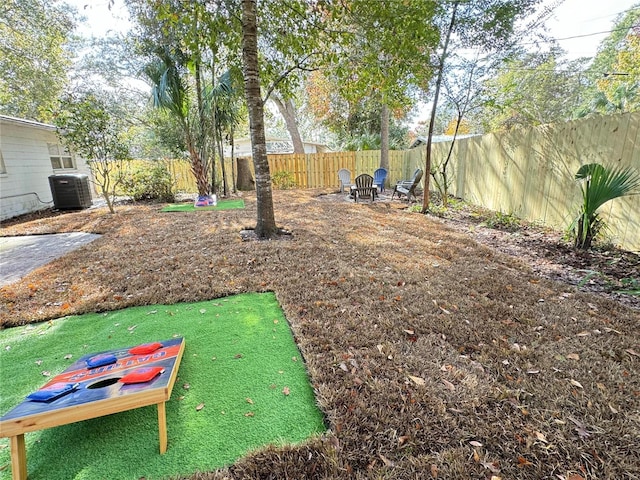 view of yard with central AC unit and a fenced backyard