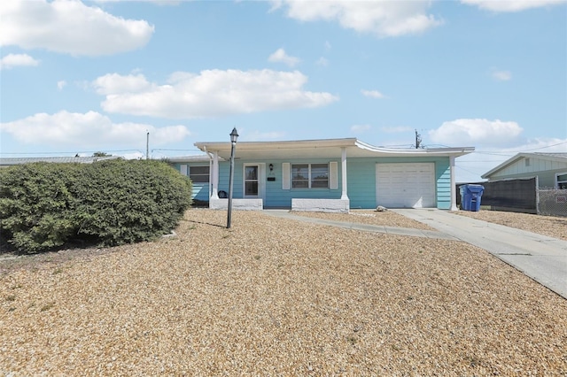 view of front of house featuring concrete driveway, an attached garage, and fence