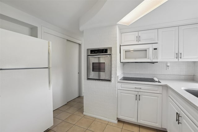 kitchen featuring light countertops, white appliances, light tile patterned flooring, and white cabinetry