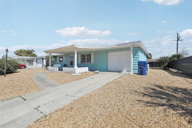 view of front facade featuring a garage, driveway, and fence