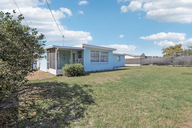 back of property with cooling unit, a sunroom, a yard, and fence