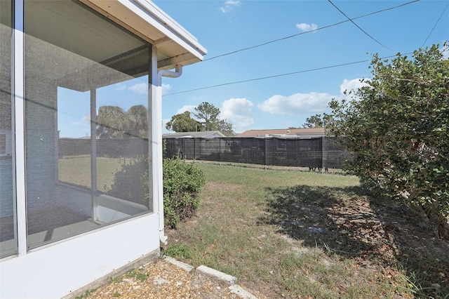 view of yard with a sunroom and fence