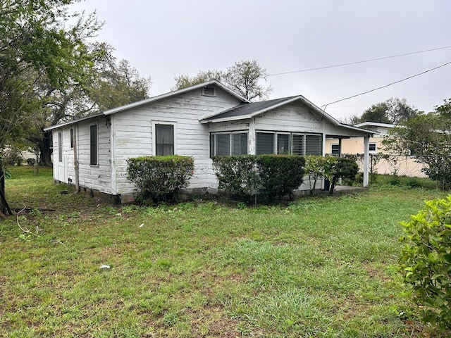 view of property exterior with a yard and fence