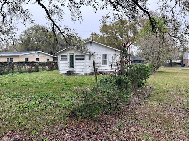 exterior space with entry steps, a lawn, and fence