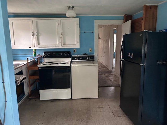 kitchen with freestanding refrigerator, washer / clothes dryer, white cabinetry, and range with electric cooktop