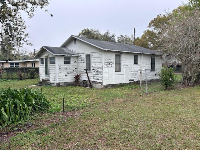 exterior space with entry steps, fence, and a yard