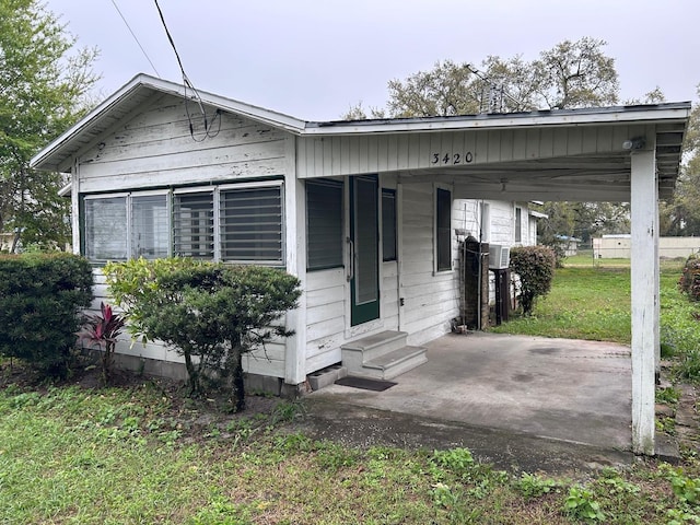 bungalow featuring entry steps, a carport, and a front yard