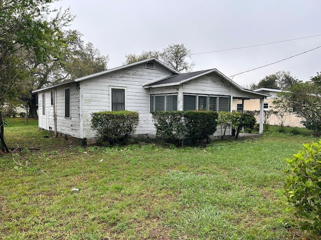 view of property exterior with a yard and fence