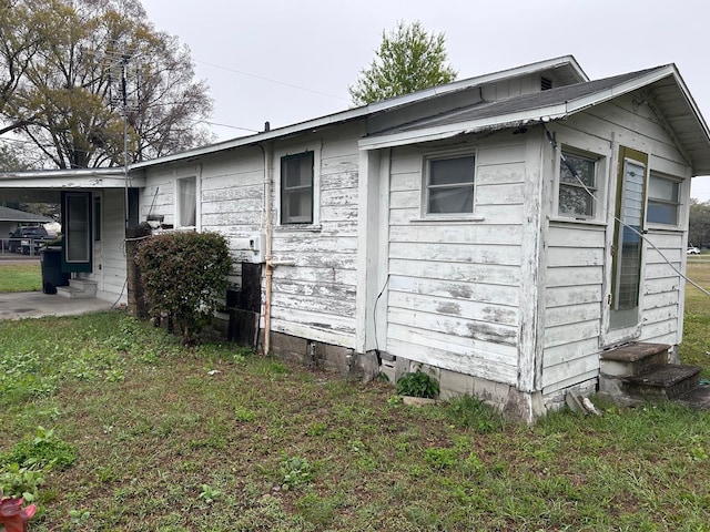 view of side of property featuring entry steps, crawl space, and a lawn