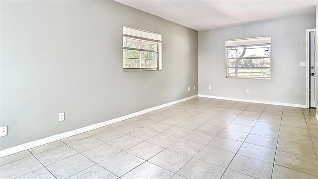 unfurnished room featuring light tile patterned floors and baseboards