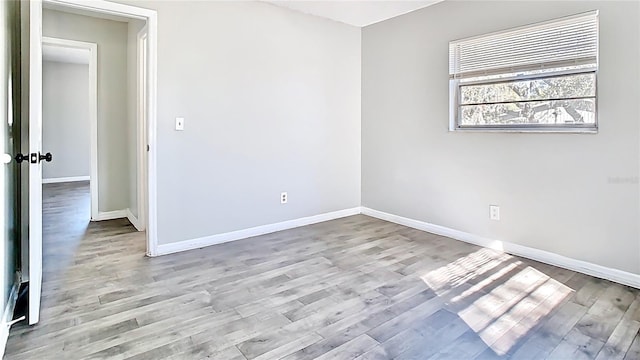 unfurnished room featuring baseboards and wood finished floors