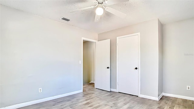 unfurnished bedroom with light wood finished floors, visible vents, and baseboards