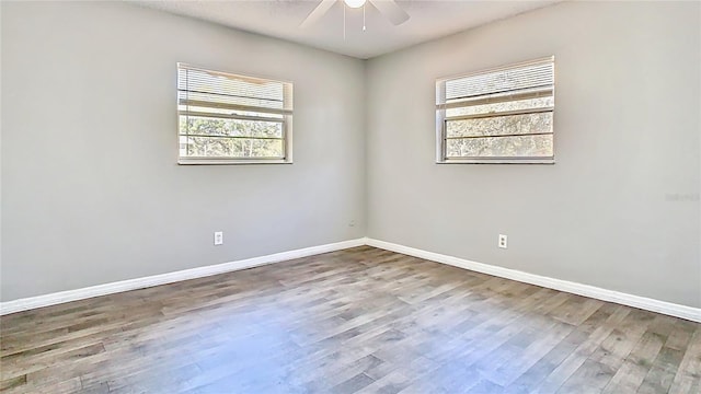 unfurnished room featuring wood finished floors, baseboards, and ceiling fan