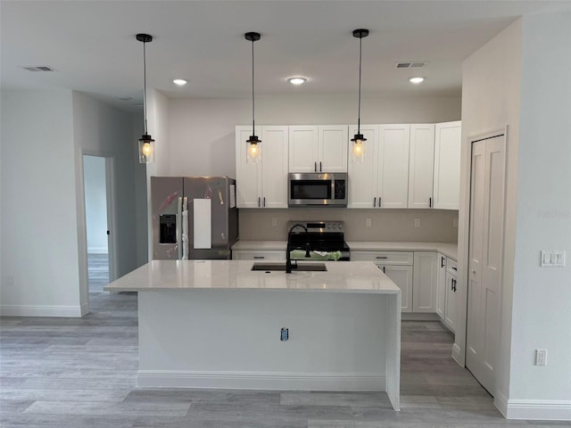 kitchen featuring appliances with stainless steel finishes, a kitchen island with sink, white cabinets, and visible vents