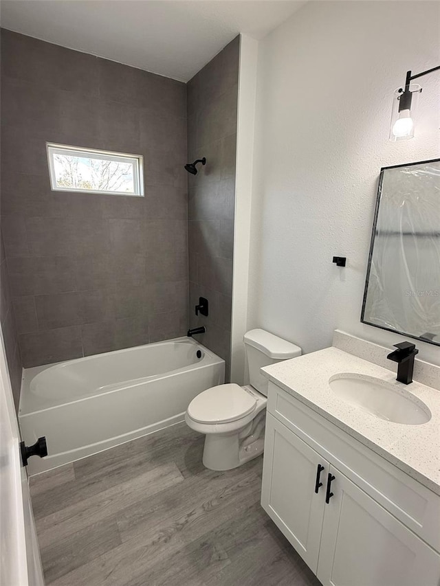 bathroom featuring  shower combination, vanity, toilet, and wood finished floors