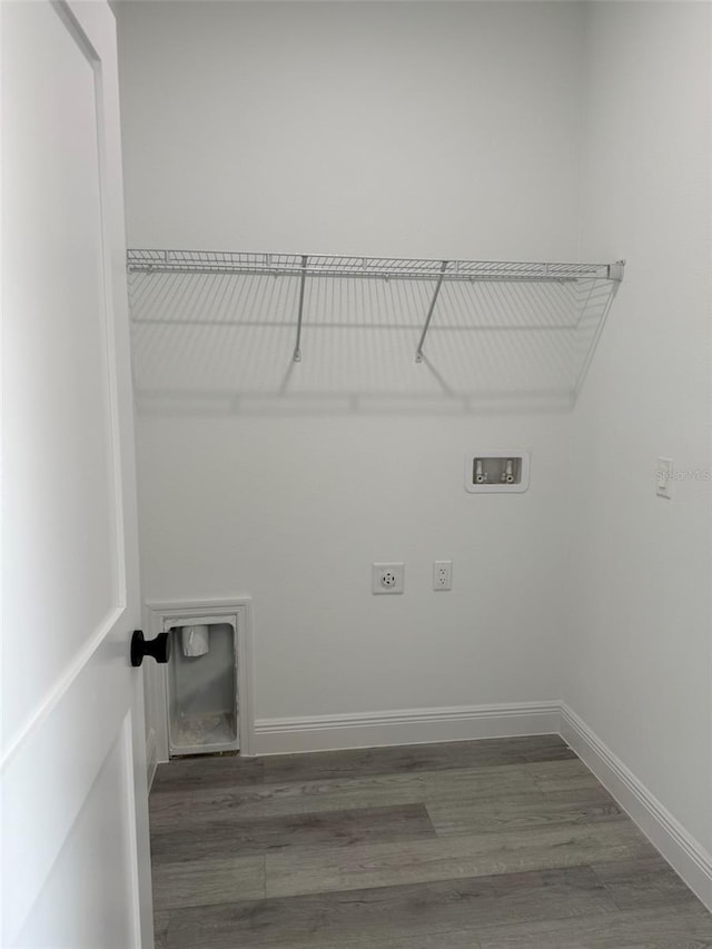 clothes washing area with hookup for a washing machine, hookup for an electric dryer, laundry area, wood finished floors, and baseboards