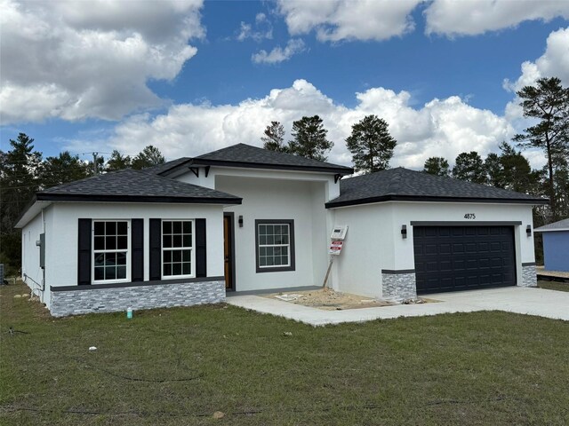 view of front of property with a garage, stone siding, a front lawn, and driveway