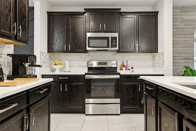 kitchen featuring appliances with stainless steel finishes, light countertops, dark brown cabinets, and tasteful backsplash