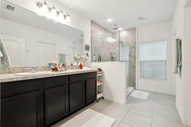 bathroom with visible vents, a sink, a shower stall, and tile patterned floors