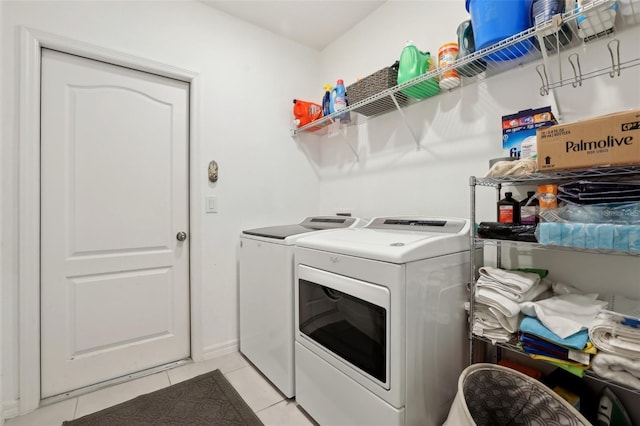 washroom with light tile patterned floors, laundry area, and washing machine and clothes dryer