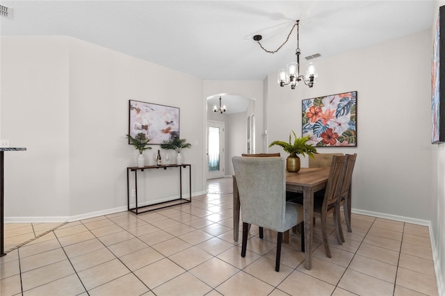 dining space with arched walkways, light tile patterned flooring, visible vents, and a notable chandelier