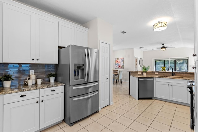 kitchen featuring stainless steel appliances, visible vents, decorative backsplash, white cabinetry, and a sink