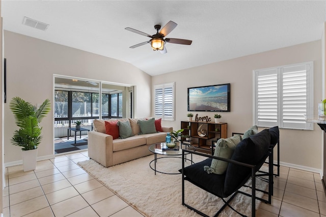 living area with light tile patterned floors, ceiling fan, visible vents, baseboards, and vaulted ceiling