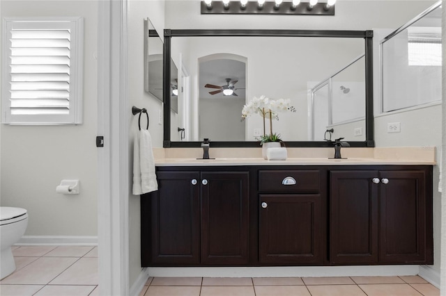 bathroom featuring a ceiling fan, tile patterned flooring, a sink, and a shower stall