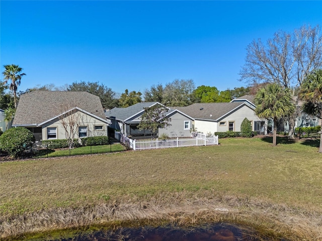 view of front of house featuring fence and a front lawn