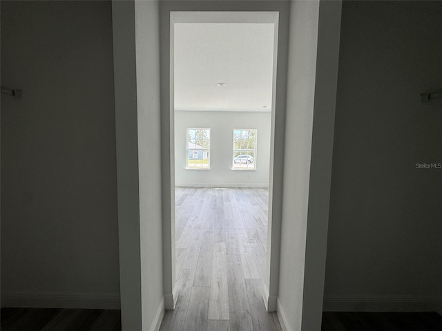 corridor featuring wood finished floors and baseboards