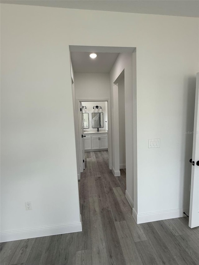 hallway with dark wood finished floors and baseboards