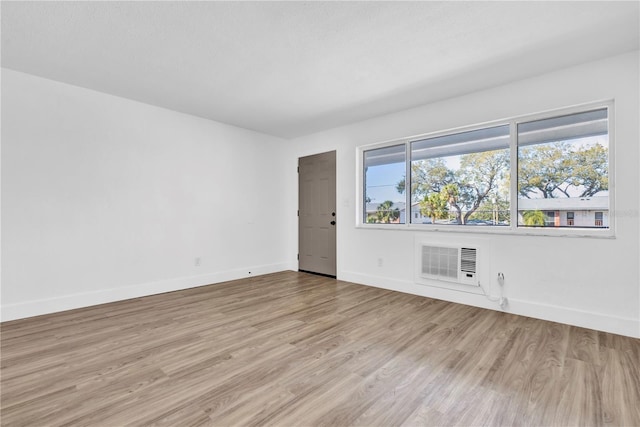 empty room featuring light wood-type flooring and baseboards