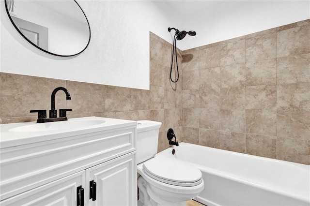 bathroom featuring tile walls, vanity, toilet, and shower / bathtub combination