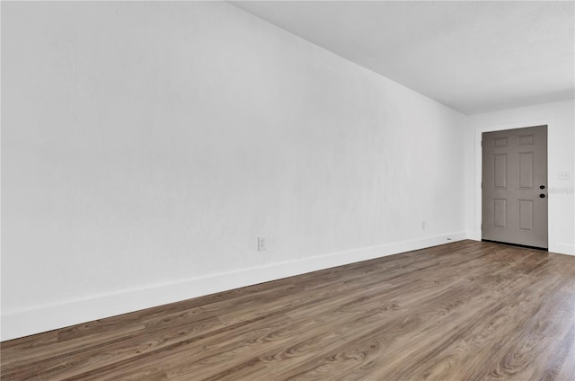 unfurnished room with wood finished floors and baseboards