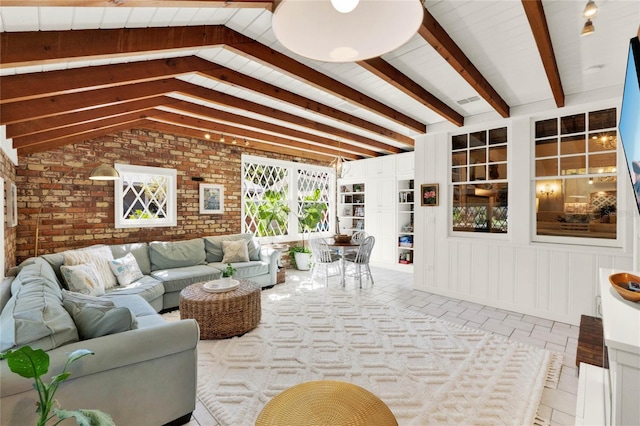 living room featuring vaulted ceiling with beams and brick wall