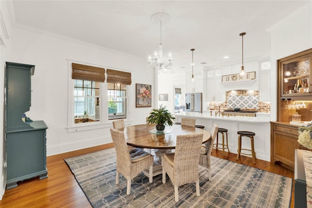 dining area with baseboards, a chandelier, dark wood-type flooring, and ornamental molding