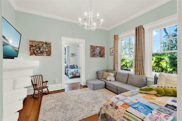 living room with a notable chandelier, baseboards, ornamental molding, and wood finished floors